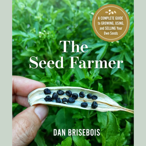 La couverture du livre "Livre - The Seed Farmer PRÉ-COMMANDE pour 26 Novembre" de Dan Brisebois, offert par TS, met en valeur une main tenant une gousse ouverte contenant des graines noires sur un fond de feuilles vertes. Un badge doré dans le coin supérieur droit indique : « Un guide complet pour cultiver, utiliser et vendre vos propres graines anciennes pour un système alimentaire local durable.